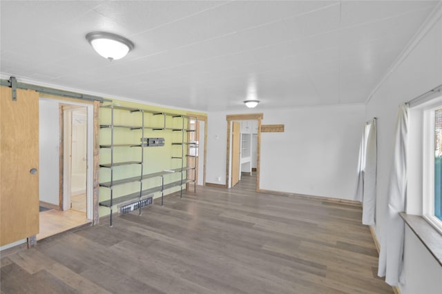 2133 W Sussex Ave, Missoula, MT 59801 - empty room featuring wood finished floors, baseboards, a barn door, and ornamental molding