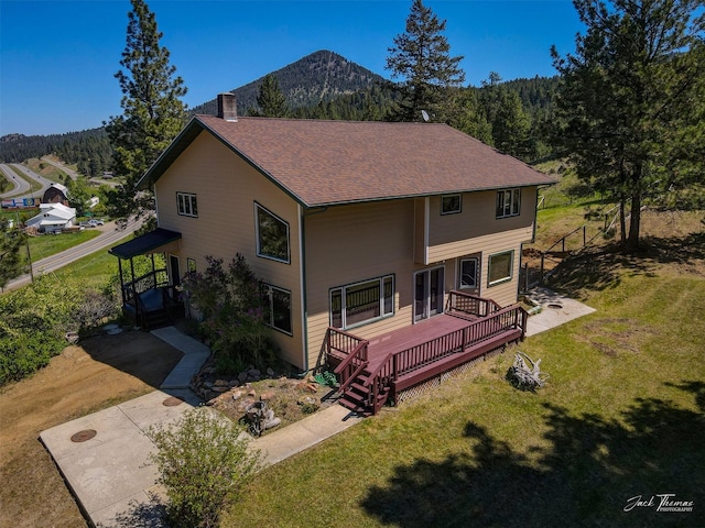 854 State Highway 282, Clancy, MT 59634 - rear view of house with a yard, a chimney, a deck with mountain view, and a shingled roof