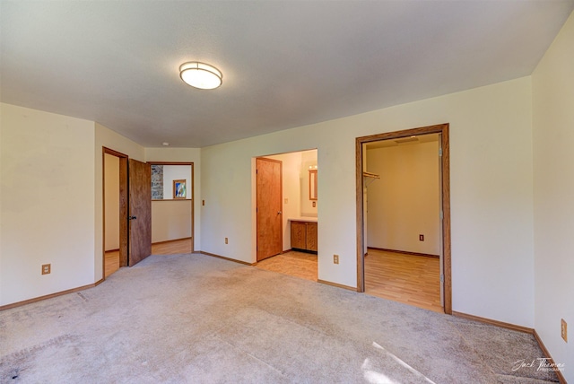 854 State Highway 282, Clancy, MT 59634 - unfurnished bedroom with light colored carpet, a spacious closet, and ensuite bathroom