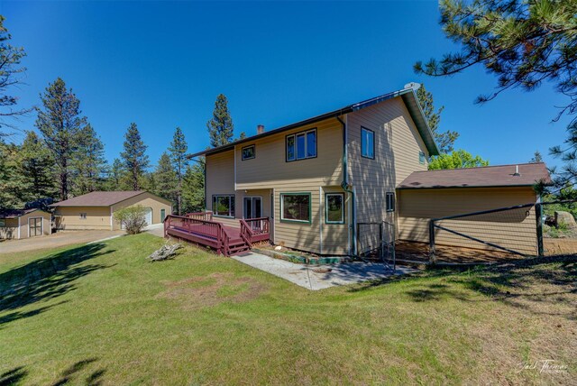 854 State Highway 282, Clancy, MT 59634 - rear view of property featuring a chimney, a deck, a detached garage, and a yard