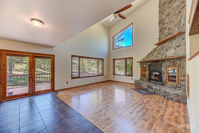 854 State Highway 282, Clancy, MT 59634 - unfurnished living room with a fireplace, ceiling fan, high vaulted ceiling, french doors, and wood finished floors