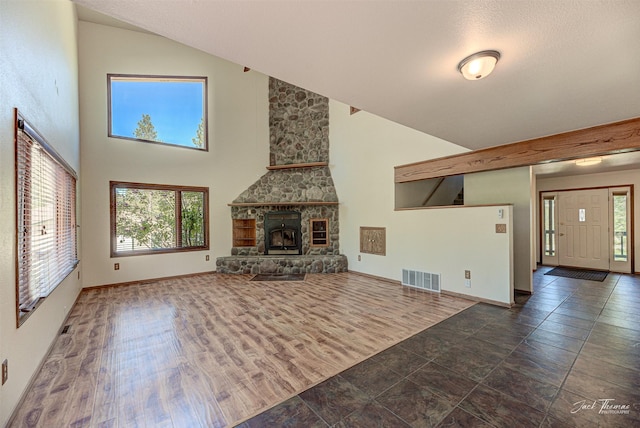 854 State Highway 282, Clancy, MT 59634 - unfurnished living room featuring high vaulted ceiling and a stone fireplace