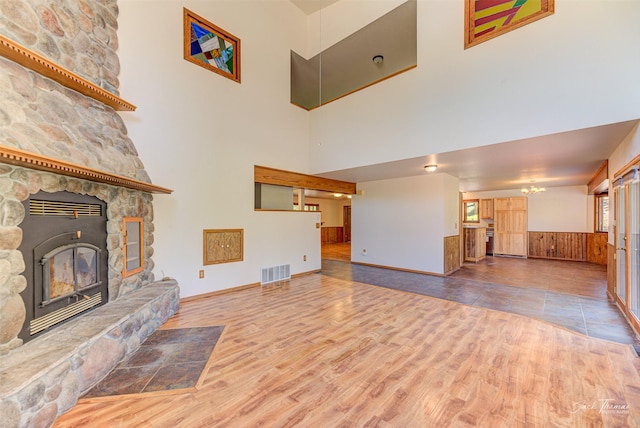 854 State Highway 282, Clancy, MT 59634 - unfurnished living room featuring a towering ceiling, wood finished floors, and a wainscoted wall