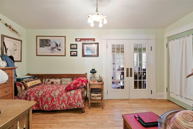 1003 N Burnt Fork Rd, Stevensville, MT 59870 - bedroom with french doors, hardwood / wood-style flooring, and a chandelier