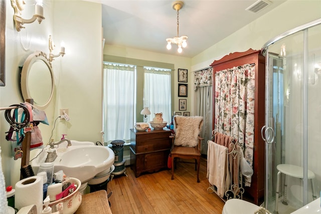 1003 N Burnt Fork Rd, Stevensville, MT 59870 - full bath with a stall shower, hardwood / wood-style flooring, and a chandelier