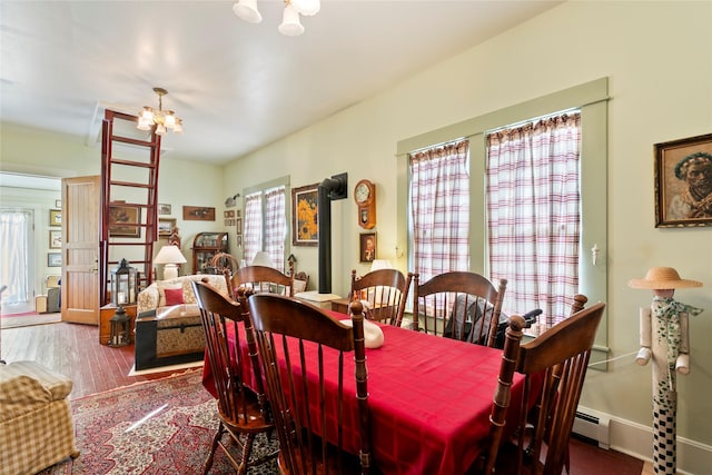 1003 N Burnt Fork Rd, Stevensville, MT 59870 - dining space with a chandelier, wood finished floors, and a baseboard radiator