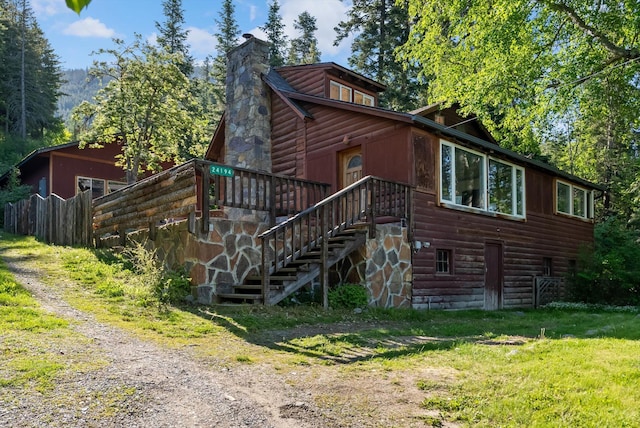 24194 Mt Highway 35, Bigfork, MT 59911 - view of front of property featuring faux log siding, a chimney, stairs, and driveway
