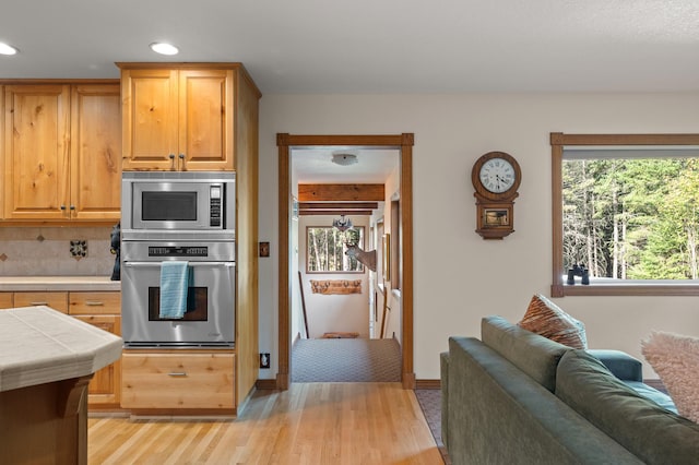 176 Blaine Ridge Rd, Kalispell, MT 59901 - kitchen with appliances with stainless steel finishes, tile countertops, light wood-style flooring, decorative backsplash, and recessed lighting