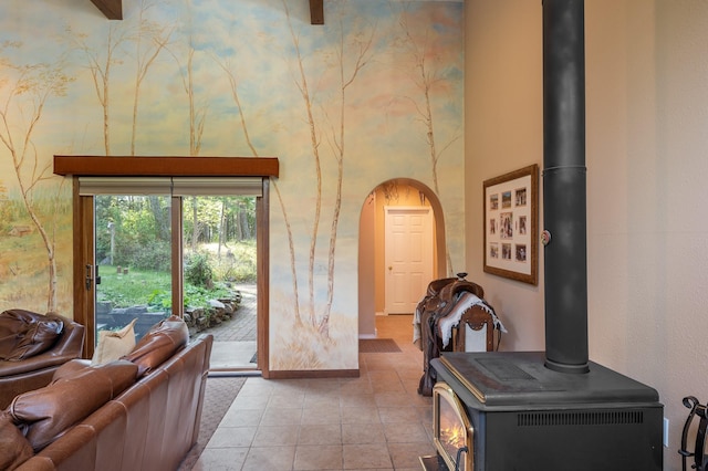 176 Blaine Ridge Rd, Kalispell, MT 59901 - tiled living room featuring a wood stove, arched walkways, and a high ceiling