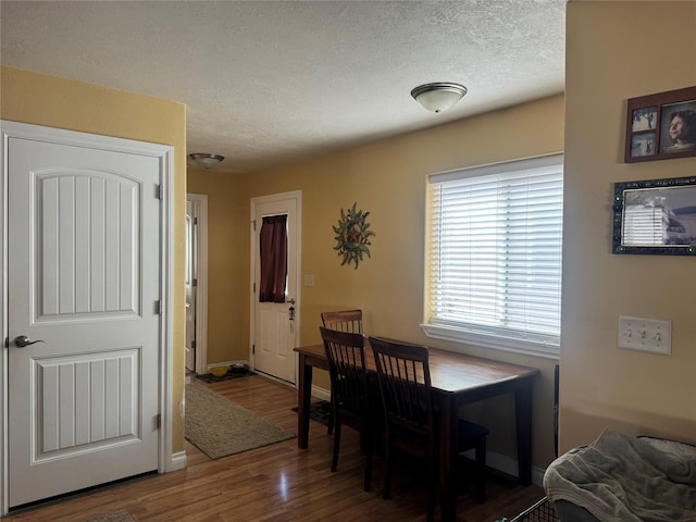 120 N 8th St, Hamilton, MT 59840 - dining room with wood finished floors, a textured ceiling, and baseboards