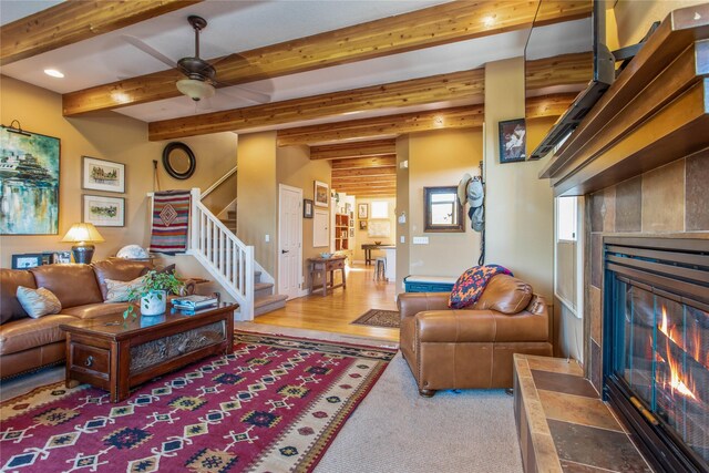 267 Eagle Bend Dr, Bigfork, MT 59911 - living area featuring a tile fireplace, stairs, recessed lighting, beamed ceiling, and ceiling fan