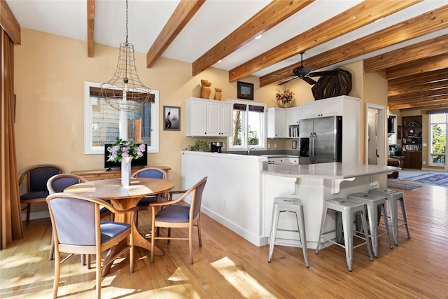 267 Eagle Bend Dr, Bigfork, MT 59911 - kitchen featuring stainless steel fridge with ice dispenser, light wood-style floors, a peninsula, ceiling fan, and white cabinets