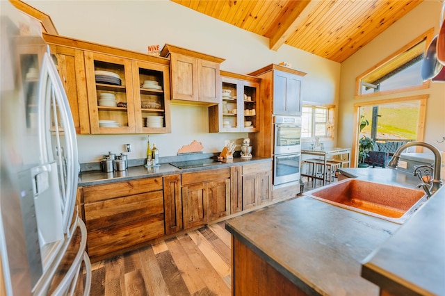 7 Papson Ridge Ln, Hall, MT 59837 - kitchen featuring freestanding refrigerator, double oven, wooden ceiling, light wood-style floors, and glass insert cabinets