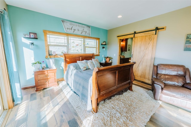 7 Papson Ridge Ln, Hall, MT 59837 - bedroom featuring a barn door, wood finished floors, and recessed lighting