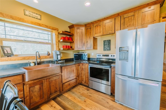 7 Papson Ridge Ln, Hall, MT 59837 - kitchen with appliances with stainless steel finishes, brown cabinetry, light wood-style floors, open shelves, and dark countertops