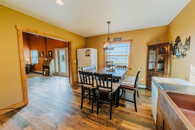 7 Papson Ridge Ln, Hall, MT 59837 - dining room featuring wood finished floors, a chandelier, and a baseboard heating unit