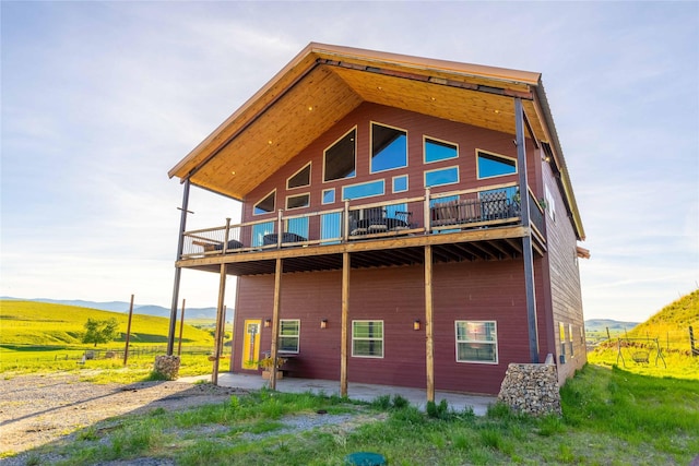 7 Papson Ridge Ln, Hall, MT 59837 - rear view of house with a balcony, a patio area, and a mountain view