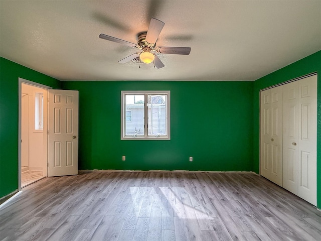 802 2nd St SW, Choteau, MT 59422 - unfurnished bedroom with wood finished floors, ceiling fan, a closet, and a textured ceiling