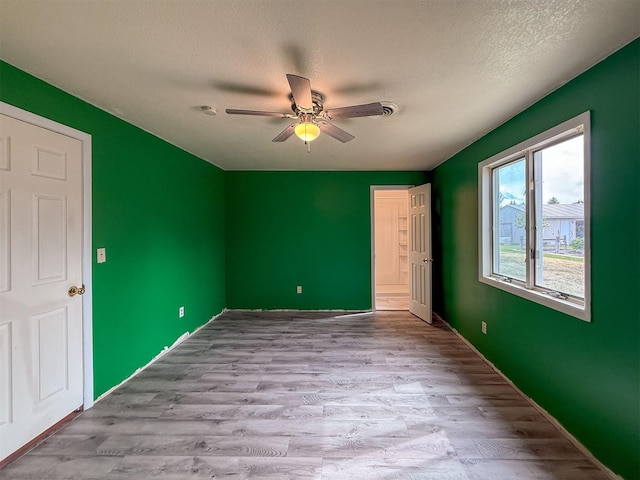 802 2nd St SW, Choteau, MT 59422 - unfurnished bedroom featuring wood finished floors, a textured ceiling, and a ceiling fan