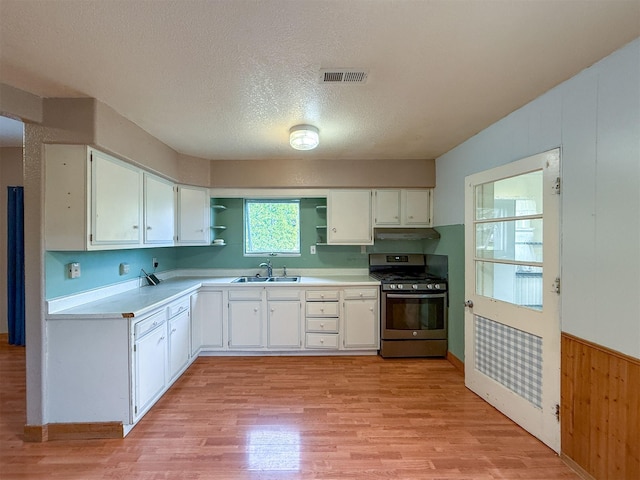 802 2nd St SW, Choteau, MT 59422 - kitchen featuring stainless steel gas range, open shelves, a sink, light wood-type flooring, and a textured ceiling