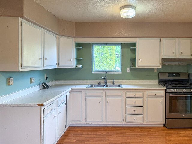 802 2nd St SW, Choteau, MT 59422 - kitchen featuring gas range, a sink, open shelves, under cabinet range hood, and white cabinets