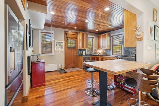 314 9th Ave W, Kalispell, MT 59901 - kitchen featuring radiator, light wood-style flooring, wood ceiling, stainless steel appliances, and brown cabinetry
