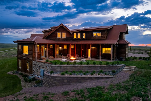 99 Little Belt Way, Belt, MT 59412 - back of property at dusk with a fire pit, a patio area, and metal roof