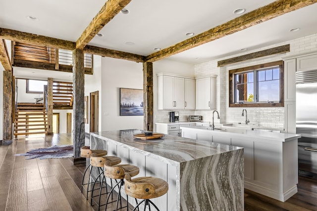 99 Little Belt Way, Belt, MT 59412 - kitchen with a kitchen island, plenty of natural light, beam ceiling, decorative backsplash, and stainless steel built in refrigerator