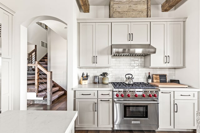 99 Little Belt Way, Belt, MT 59412 - kitchen featuring designer stove, under cabinet range hood, light countertops, and arched walkways