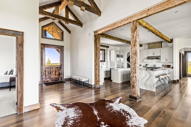 99 Little Belt Way, Belt, MT 59412 - living area featuring beamed ceiling, arched walkways, healthy amount of natural light, dark wood-style flooring, and baseboards