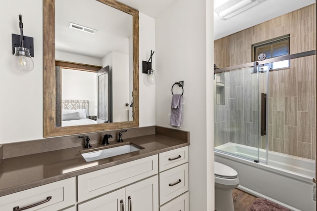 99 Little Belt Way, Belt, MT 59412 - full bathroom with vanity, toilet, ensuite bath, bath / shower combo with glass door, and wood finished floors