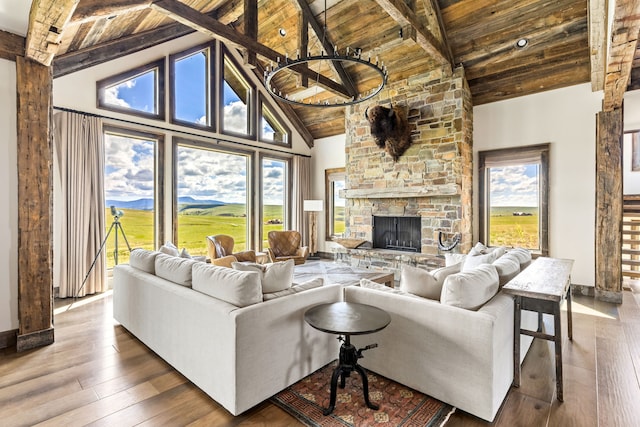 99 Little Belt Way, Belt, MT 59412 - living room with wood ceiling with exposed beams, wood-type flooring, baseboards, high vaulted ceiling, and a stone fireplace