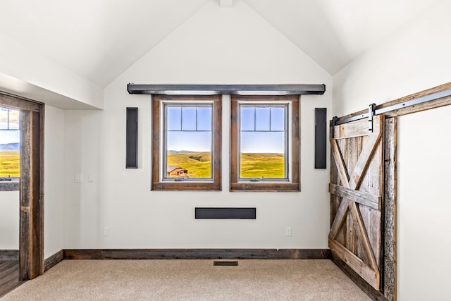 99 Little Belt Way, Belt, MT 59412 - unfurnished room featuring vaulted ceiling, carpet, baseboards, and a barn door