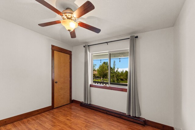 370 Prospector Trl, Bozeman, MT 59718 - empty room featuring a baseboard heating unit, light wood finished floors, baseboards, and a ceiling fan