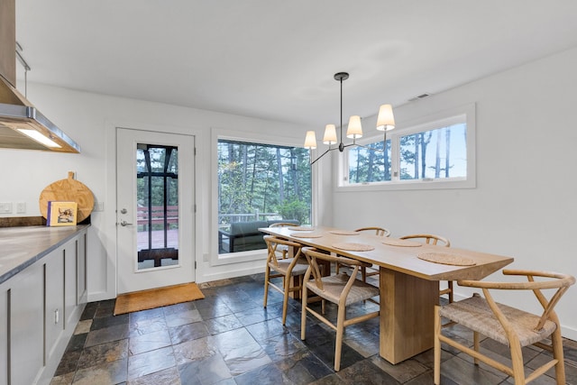 33535 Cherry Ln, Bigfork, MT 59911 - dining room with stone tile floors, plenty of natural light, and a chandelier