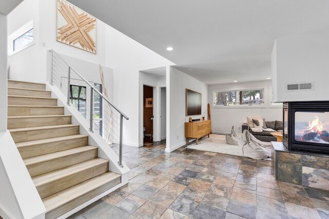 33535 Cherry Ln, Bigfork, MT 59911 - entryway with stone tile floors, stairs, a multi sided fireplace, and recessed lighting