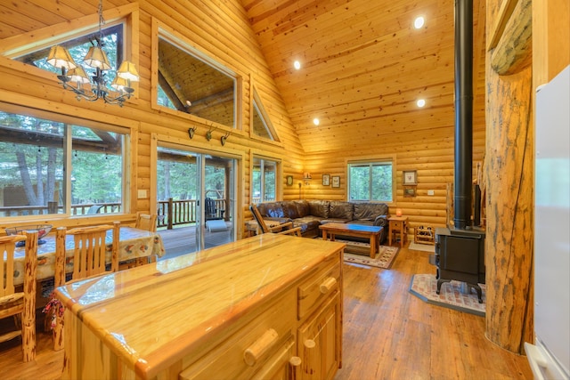 288 Trout Dr, Rexford, MT 59930 - dining space featuring log walls, a wood stove, high vaulted ceiling, a chandelier, and wooden ceiling
