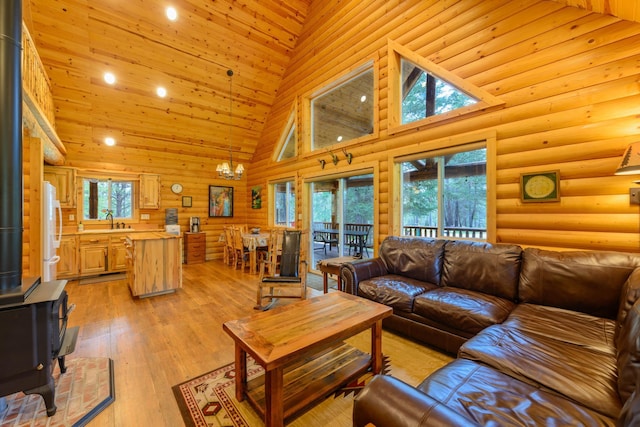 288 Trout Dr, Rexford, MT 59930 - living area featuring a wood stove, a high ceiling, a chandelier, light wood-type flooring, and recessed lighting