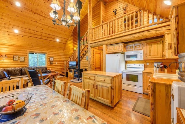 288 Trout Dr, Rexford, MT 59930 - kitchen with white appliances, log walls, a wood stove, light countertops, and high vaulted ceiling