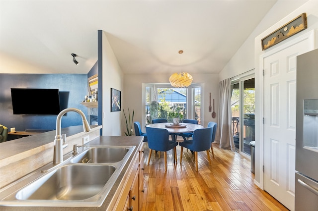 3197 Rose St, Bozeman, MT 59718 - kitchen featuring a sink, vaulted ceiling, healthy amount of natural light, light wood-type flooring, and pendant lighting
