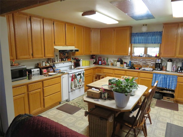 13567 Rosco Rd, Alberton, MT 59820 - kitchen with white range with electric cooktop, under cabinet range hood, stainless steel microwave, light countertops, and a sink