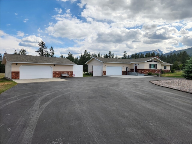 127 Patricia Way, Hamilton, MT 59840 - view of front facade featuring brick siding, a mountain view, and a detached garage