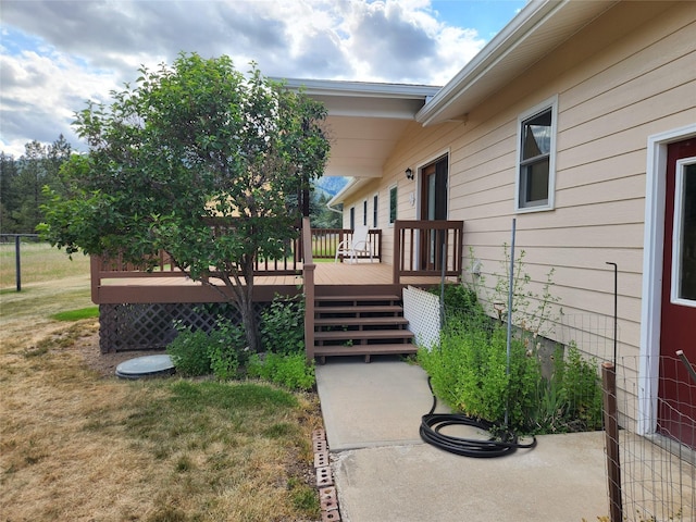 127 Patricia Way, Hamilton, MT 59840 - view of exterior entry with a wooden deck and a lawn