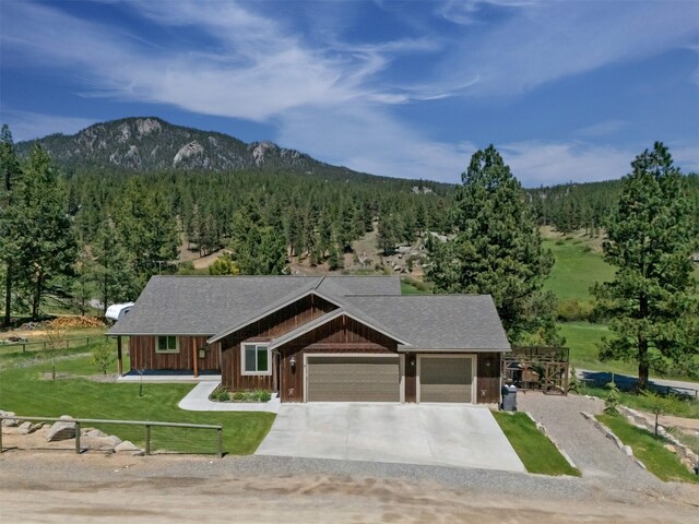 4 Juniper Ln, Clancy, MT 59634 - view of front of home featuring a view of trees, concrete driveway, an attached garage, and board and batten siding