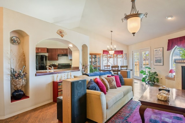 142 Thomas St, Hamilton, MT 59840 - living area with wood finished floors, lofted ceiling, a chandelier, and arched walkways