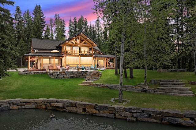 501 Forbidden Ln, Condon, MT 59826 - back of property at dusk featuring a yard, metal roof, and a patio area