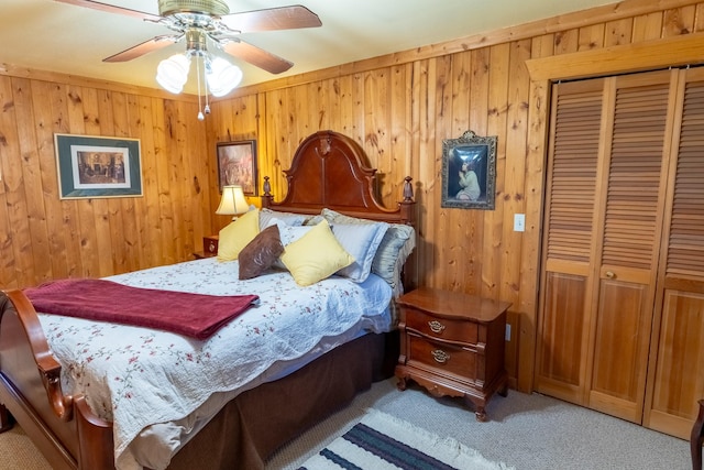 347 Upper Ross Gulch Rd, Townsend, MT 59644 - bedroom featuring a closet, light colored carpet, wooden walls, and a ceiling fan
