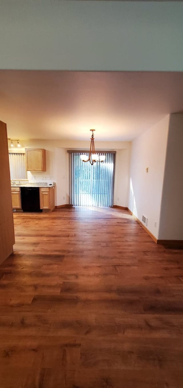 42843 Jette Lake Trl, Polson, MT 59860 - unfurnished living room with wood finished floors, a chandelier, and baseboards