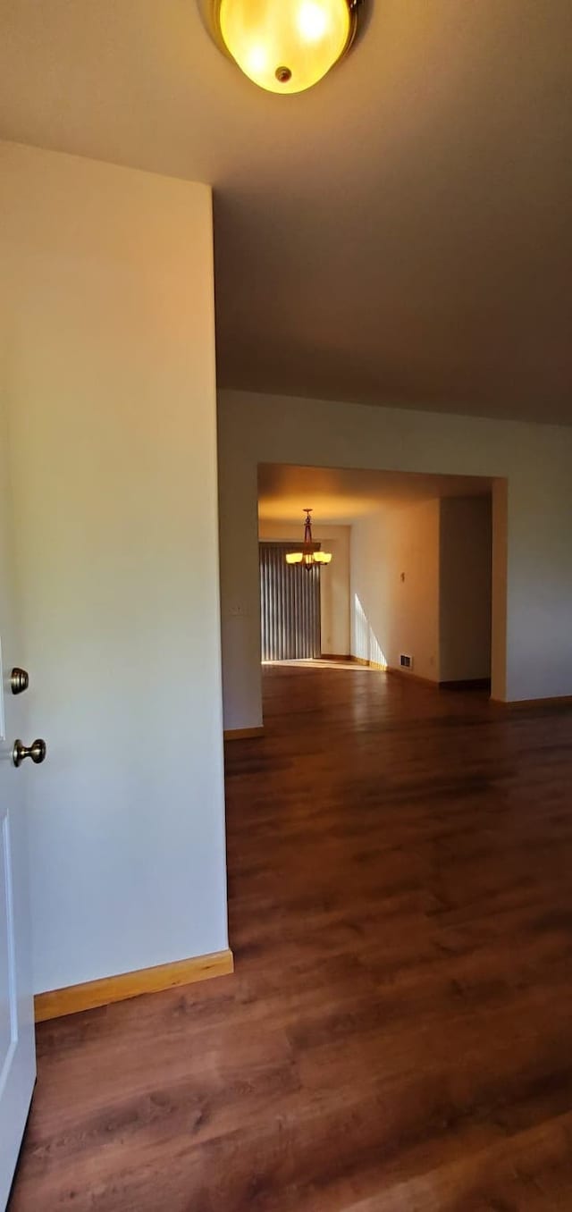 42843 Jette Lake Trl, Polson, MT 59860 - unfurnished room featuring a chandelier, wood finished floors, and baseboards