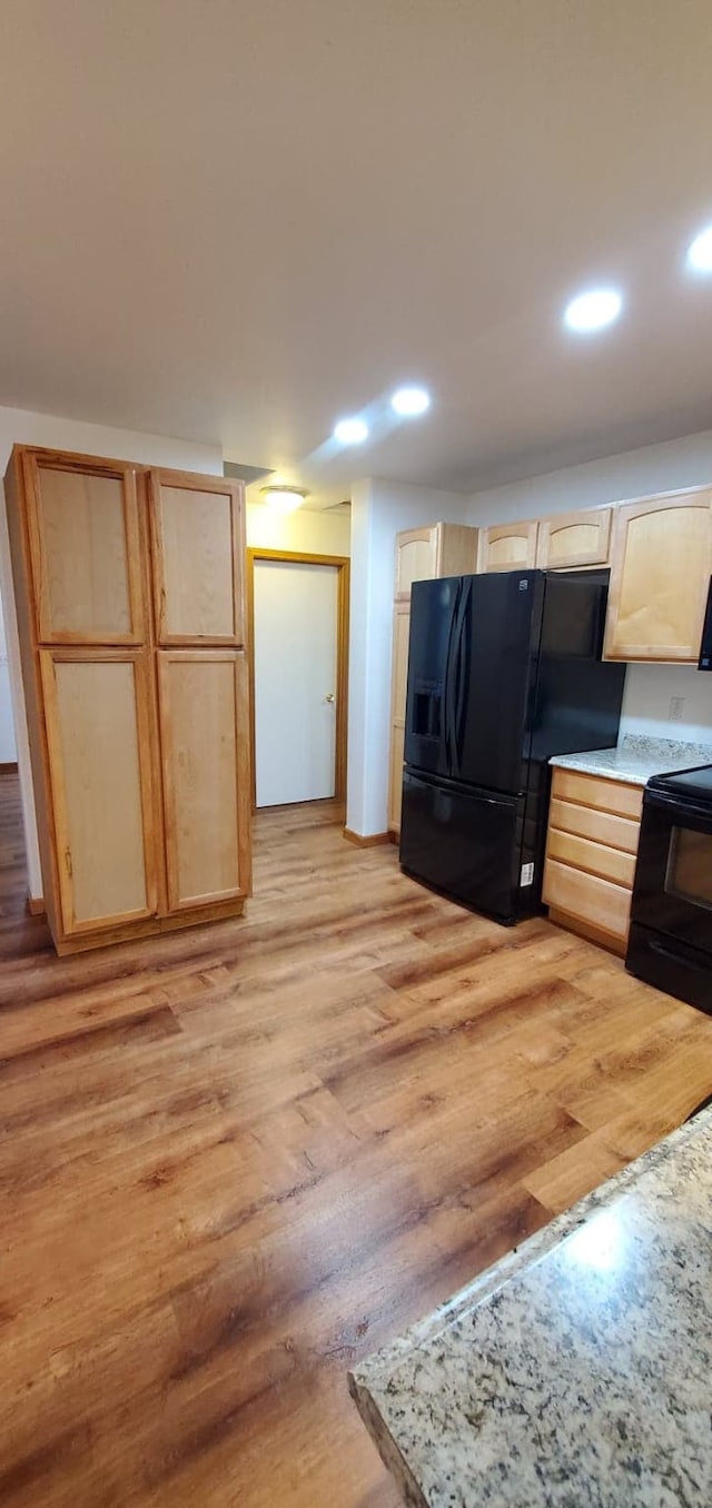 42843 Jette Lake Trl, Polson, MT 59860 - kitchen featuring black appliances, light brown cabinetry, light wood-style flooring, recessed lighting, and light countertops
